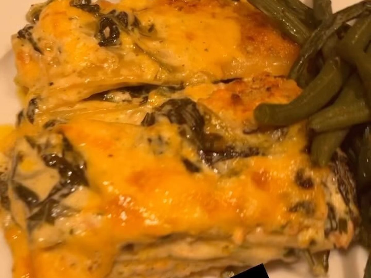 Baked seafood lasagna with a browned cheese top in a foil tray