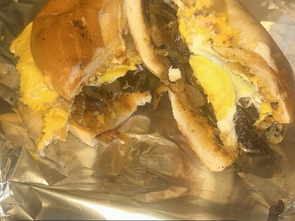 A steak, egg and cheese sandwich on a toasted bagel wrapped in foil